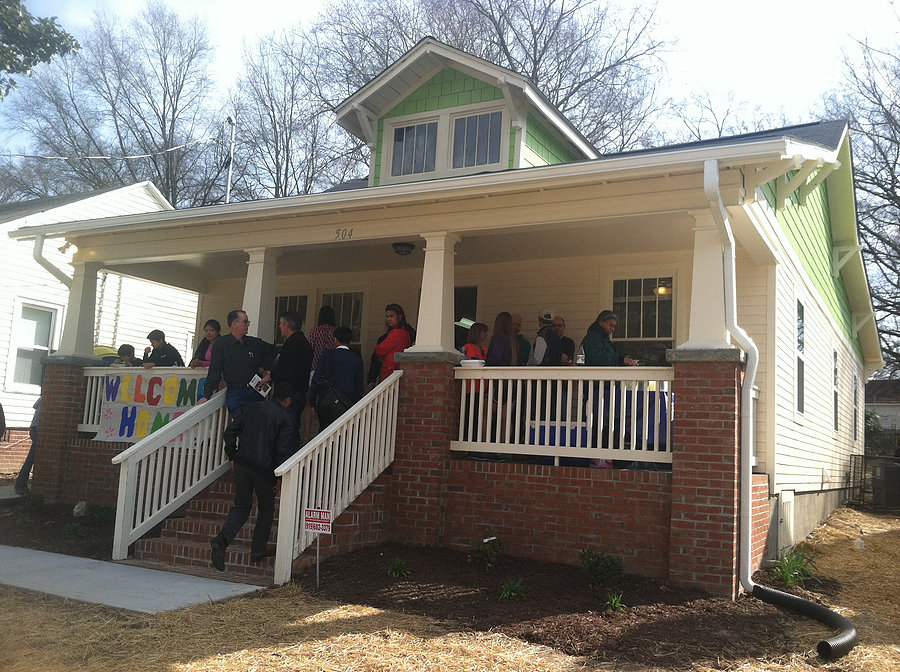 volunteers posing on front porch of house